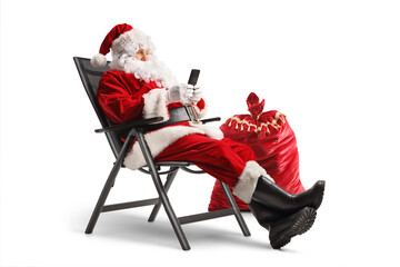 Santa claus sitting in a foldable chair and using a smartphone
