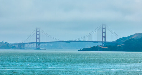 Golden Gate Bridge covered in hazy fog aerial of full bridge side view