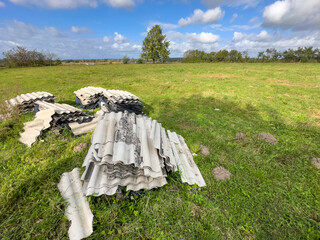 Heap of asbestos roof tiles abandoned in a field