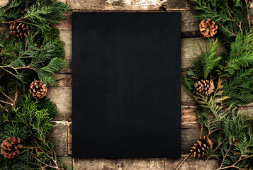 Realistic A4 poster mockup with black canvas on Christmas mood background on a tree with cones and needles, printed texture for posters, greeting cards, banners, web, landings, paintings and other 
