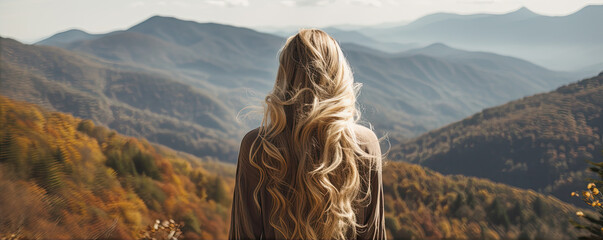 Woman with long wavy blond hairs with nature in background.  Dense long blonde hair rear view - obrazy, fototapety, plakaty