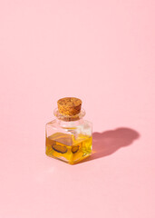 Truffle oil on a pink background. Method for preserving truffles. Season of black truffle. Autumn gourmet cuisine of Piedmont, Italy, Spain and France