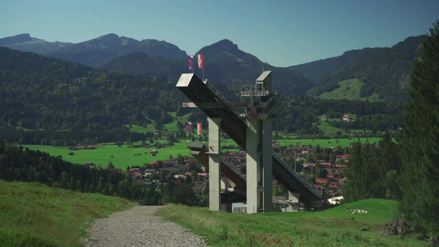 World famous Ski Jump Arena in Oberstdorf Germany. Skiflugschanze Bayern. View of ski jumping hill Audi Arena, part of famous Four Hills Tournament, on sunny day in summer with Allgau mountains. 