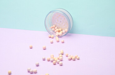 Fototapeta na wymiar Jar balls of powder for make-up on pastel background