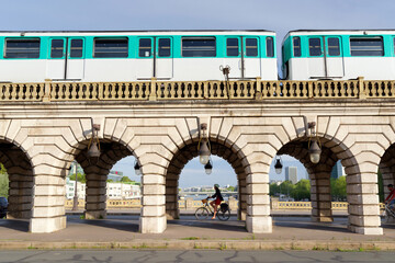 Subway train and cyclist on the Bercy bridge in Paris city