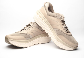 Pair of beige leather running shoes isolated on white background