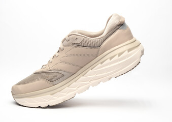 Levitating beige sneaker for running on a white background