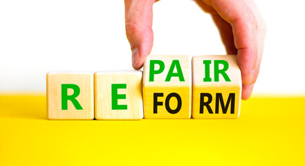 Reform and repair symbol. Concept words Reform Repair on wooden block. Beautiful yellow table white...