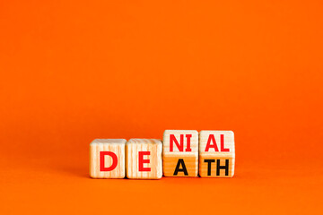 Denial death symbol. Concept words Denial Death on wooden block. Beautiful orange table orange background. Business denial death concept. Copy space.
