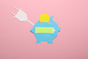 Paper-cut piggy bank with fully charged battery and electric plug on pink background
