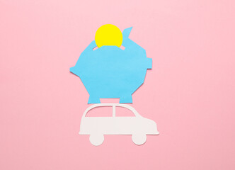 Paper-cut piggy bank with car on pink background.
