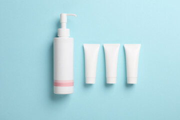 White cream tube and lotion dispenser on blue background