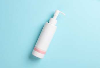 White lotion dispenser on blue background