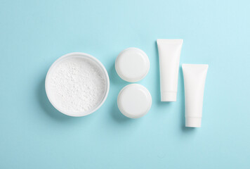 Mockup of cream tubes and tooth powder on a blue background. flat lay. Beauty concept
