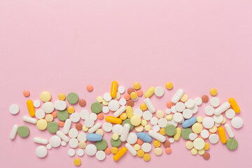 Different medical pills and capsules on color background, top view