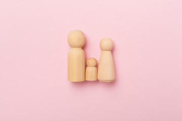 Wooden family figures on color background, top view