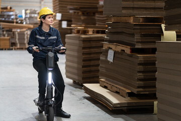 Caucasian Businesswoman ride scooter and checking wood Kraft stock at factory © chachamp