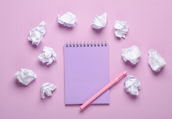 Crumpled paper balls with notebook on a pastel background. Business concept