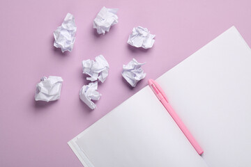 Crumpled paper balls with open notebbok on pastel background. Education, Business concept