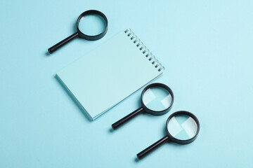 Notepad with magnifiers on a blue background. Education, business concept