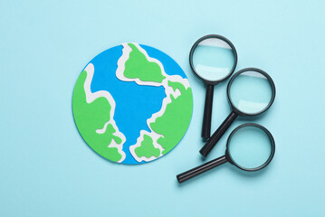 Globe with magnifiers on a blue background. Travel concept