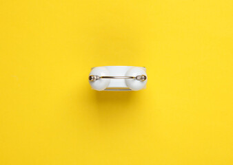 Top view of alarm clock bell on yellow background
