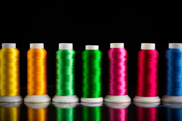 set of different color sewing threads,on black background.