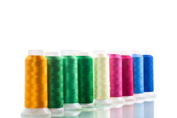 set of different color sewing threads,on white background.