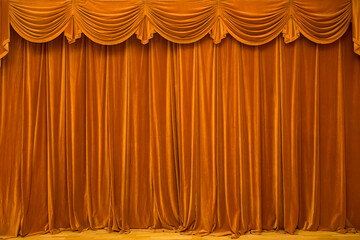 A mustard-colored theater curtain with a lambrequin closed on the stage