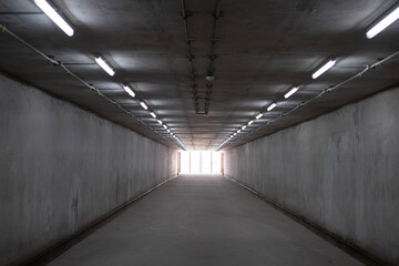 Underground Parking Garage. Concrete tunnel and bright light at the destination