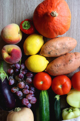 Reusable mesh bag with seasonal fruit and vegetable on wooden background. Late summer or early autumn. Top view.