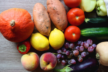 Reusable mesh bag with seasonal fruit and vegetable on wooden background. Late summer or early autumn. Top view.
