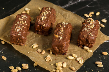 Chocolate sticks with peanuts on a dark background