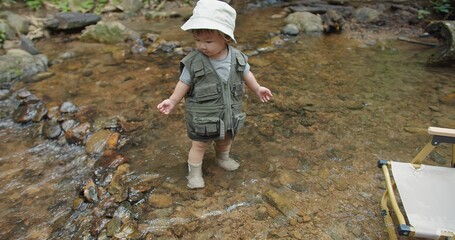 cute little Asian toddler daughter kid girl walking playing mountain river water nature in forest natural background, adventure camping travel trip