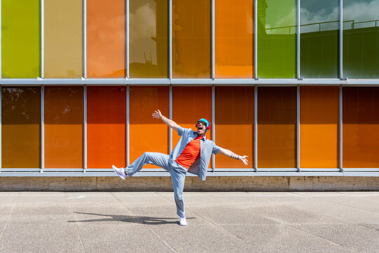 Man's lively dance by colorful building