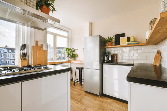 Kitchen with appliances and cabinets by window