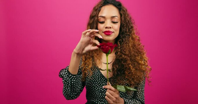 Beautiful young woman plays 'He loves me, he loves me not' game with red rose