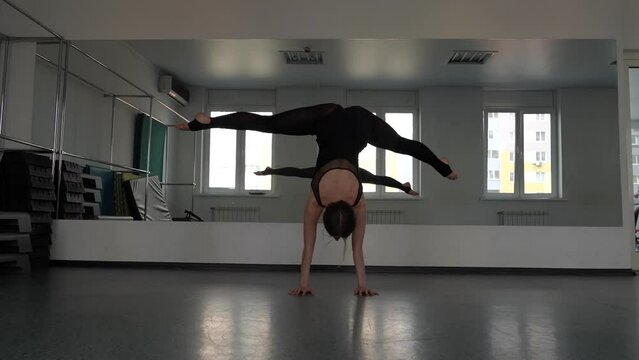 girl gymnast pulls leg to head arching in the back, stretching in studio. High quality footage, Legs Of Woman Gymnast Closeup Sports Center Physical Strength Motivation Gymnastics Concept YOGA