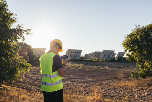 Technical man taking data next to some solar panels