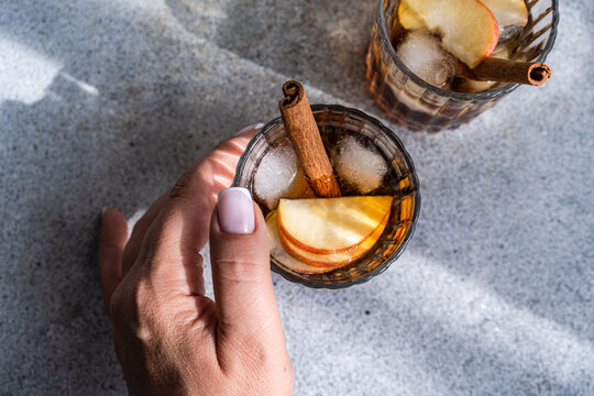 Hand holding apple cider drinks