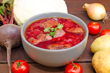 Borscht soup with vegetables and meat on a wooden table