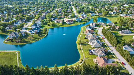 Wide view of expensive neighborhood with large pond and two water fountains