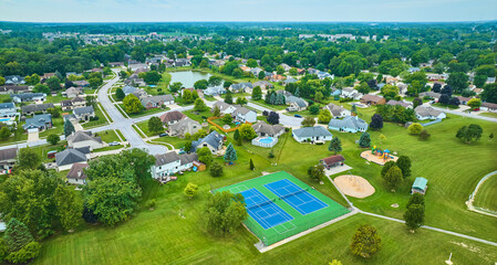 Aerial suburban neighborhood with tennis court and playground - obrazy, fototapety, plakaty