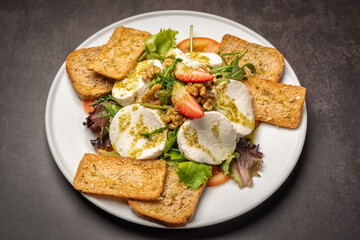 A wonderful healthy breakfast of mozzarella cheese, strawberry salad and croutons.