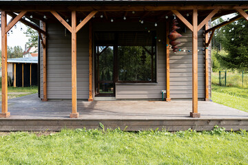 Old weathered wooden deck and new facade of a modern house