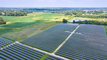 Aerial Midwest solar farm with solar panels in rural area near farmland and swamp