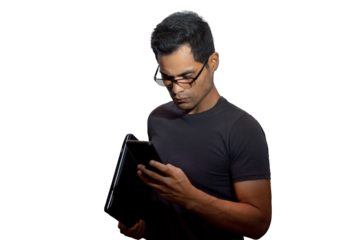Young Latino with glasses and laptop, looking serious at his phone. Networking concept, programming, business, cybersecurity. Isolated.