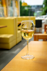 A glass of white wine on the table of an evening restaurant on the summer veranda