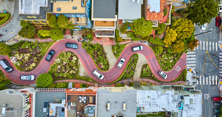 Straight down shot over Lombard Street with cars and road running horizontally through aerial