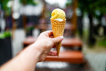Close up of men hand holding delicious ice cream waffle cone outdoor